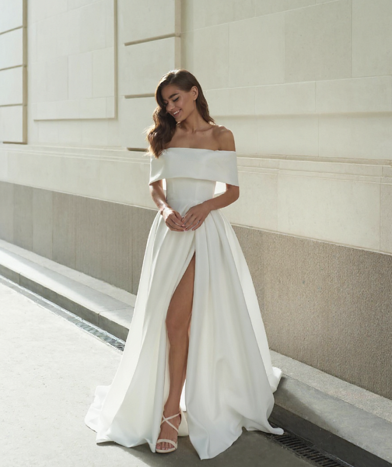 Стильное свадебное платье с открытыми плечами и эффектным разрезом но ноге